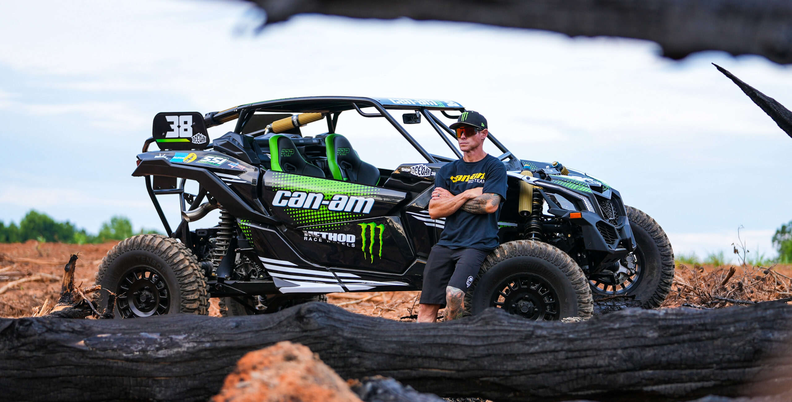Driver leans on buggy equipped with BILSTEIN Black Hawk Powersports